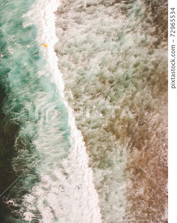Aerial view of surfers in the waves of the Aerial view of surfers in the waves of the 72965534
