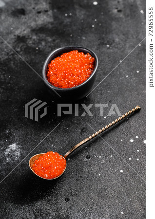 Spoon of Exquisite red caviar. Black background. 72965558