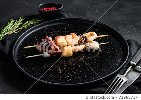 Wooden skewers with shrimp, octopus, squid and Wooden skewers with shrimp, octopus, squid and 72965717