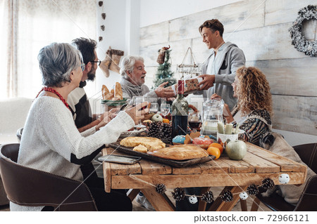 Family enjoy together christmas lunch at home - caucasian people have fun in friendship celebrating holidays and eve - white home and wooden style table Family enjoy together christmas lunch at home - caucasian people have fun in friendship celebrating holidays and eve - white home and wooden style table 72966121