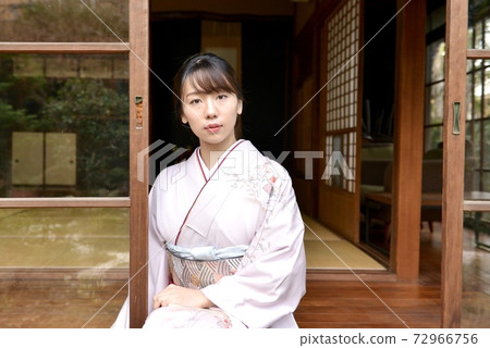 一名年輕和美麗的和服女子擺在一座老民居的邊緣 72966756