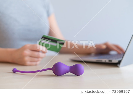 A woman is shopping online in a sex shop. The girl is looking for satisfaction on the Internet A woman is shopping online in a sex shop. The girl is looking for satisfaction on the Internet 72969107