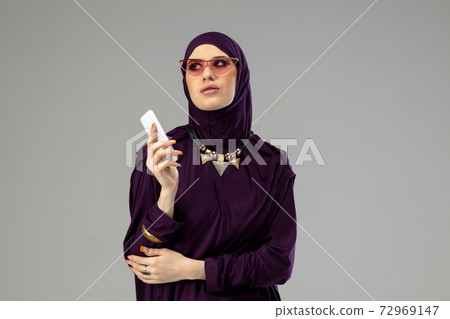 Beautiful arab woman posing in stylish hijab isolated on studio background. Fashion concept 72969147