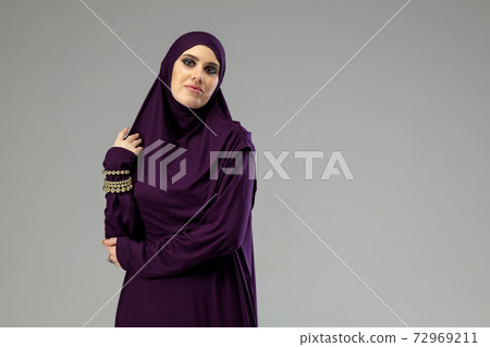 Beautiful arab woman posing in stylish hijab isolated on studio background. Fashion concept 72969211