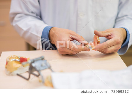 A dental technician makes partial dentures. The production of false teeth or dental bridges. Close-up. 72969212