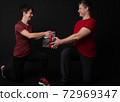Personal Trainer couple handing a gift box 72969347