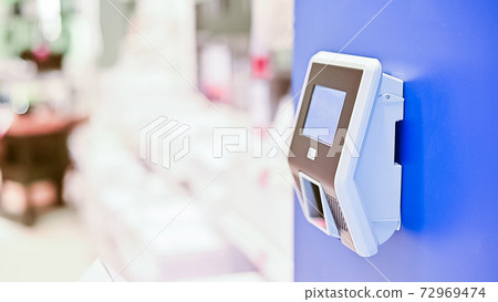 Wall mounted price scanner on a blue wall 72969474