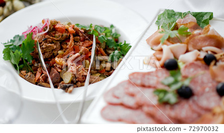 jerky on a white plate on a white table with tongs for food jerky on a white plate on a white table with tongs for food 72970032