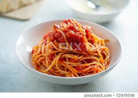 Spaghetti with tomato sauce and basil on a plate 72970590