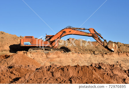 Excavator working on earthmoving at open pit mining.  72970895