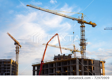 Builder workers during formworks and pouring concrete through a oncrete pump truck connected Builder workers during formworks and pouring concrete through a oncrete pump truck connected 72970909