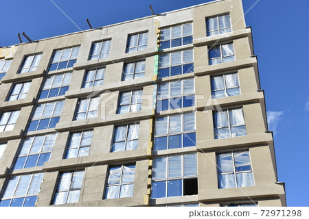 Mineral wool and plaster applied on new multi-storey building facade. Mineral wool and plaster applied on new multi-storey building facade. 72971298