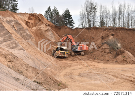 Excavator load the sand to the heavy mining truck in the open-pit. Heavy machinery Excavator load the sand to the heavy mining truck in the open-pit. Heavy machinery 72971314