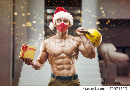 Fitness man in Santa Claus hat costume in gym Fitness man in Santa Claus hat costume in gym 72971755
