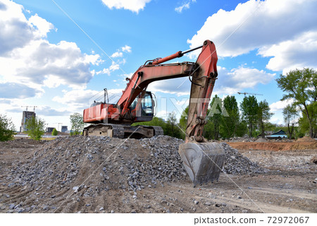 Excavator work at landfill with concrete demolition waste. Excavator work at landfill with concrete demolition waste. 72972067
