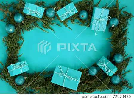 Flat lay new year Christmas blue boxes, blue balls, pine tree on blue background 72973420