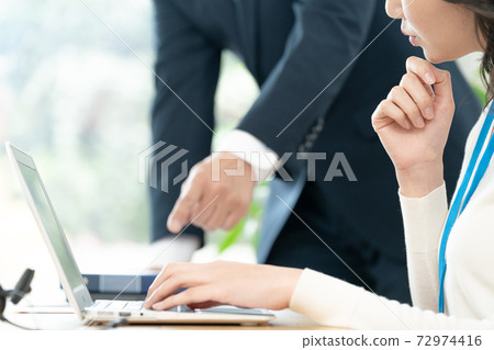 A woman receiving advice from her boss A woman receiving advice from her boss 72974416