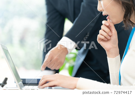A woman receiving advice from her boss A woman receiving advice from her boss 72974417