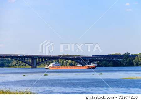 Heavy long barge sailing on the Dnieper river in Kiev, Ukraine Heavy long barge sailing on the Dnieper river in Kiev, Ukraine 72977210