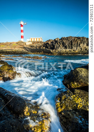 Beautiful scenic landscape with classic lighthouse on the coast and blue ocen and sky in background - concept of travel and vacation for tourism - wave and rocks 72981511