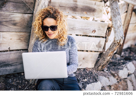 Attractive people adult blonde woman use laptop. computer outdoor - connected everywhere and digital nomad lifestyle - concept of workers in outdoors no office Attractive people adult blonde woman use laptop. computer outdoor - connected everywhere and digital nomad lifestyle - concept of workers in outdoors no office 72981606