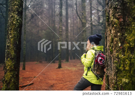 Healthy sporty woman enjoying the outdoor leisure activity with a backpack and trekking equipment in the middle of a rainy wild forest - people with alternative lifestyle and adventure need Healthy sporty woman enjoying the outdoor leisure activity with a backpack and trekking equipment in the middle of a rainy wild forest - people with alternative lifestyle and adventure need 72981613