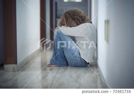 Loneliness and depression disease concept with sad woman hug herself sit down on the floor a home alone - protection needed and violence against woman and wife image Loneliness and depression disease concept with sad woman hug herself sit down on the floor a home alone - protection needed and violence against woman and wife image 72981738