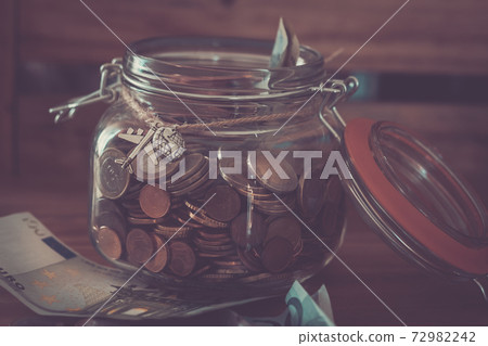 Concept of money saving ina glass transparent piggy bank for nex travel and holiday summer vacation -europe euro coin and paper Concept of money saving ina glass transparent piggy bank for nex travel and holiday summer vacation -europe euro coin and paper 72982242