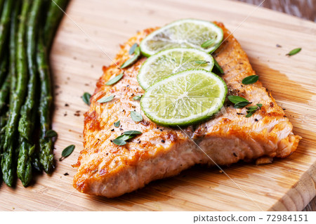 Salmon Fillet with Asparagus ready to eat on a cutting board. Salmon Fillet with Asparagus ready to eat on a cutting board. 72984151