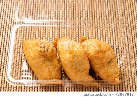 Takeout image. Inari sushi (Kansai-style triangular inari) in a transparent plastic container. 72987912