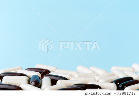 Medicine or supplement capsules on blue surface. Pharmaceutical pills and vitamins. Probiotic, glucosamine chondroitin pile. Medicine or supplement capsules on blue surface. Pharmaceutical pills and vitamins. Probiotic, glucosamine chondroitin pile. 72991712