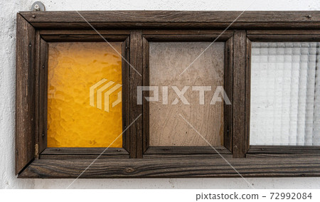 Antique wooden frame and light colored glass on white wall Antique wooden frame and light colored glass on white wall 72992084