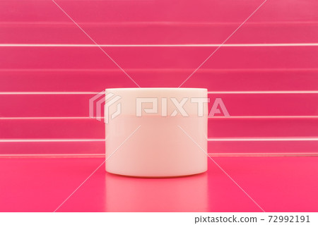 White cream jar against pink background with stripes with space for text 72992191