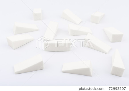 Triangle shaped make up sponges in random order on white background 72992207