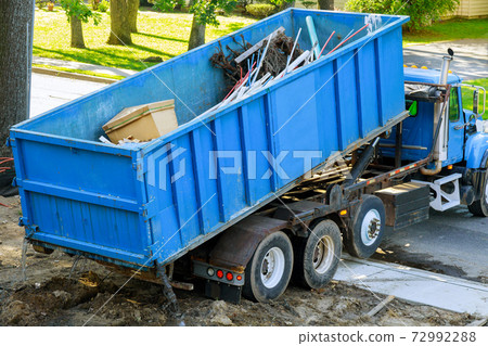 Loading the garbage container old and used construction material in the new building construction work site. Loading the garbage container old and used construction material in the new building construction work site. 72992288