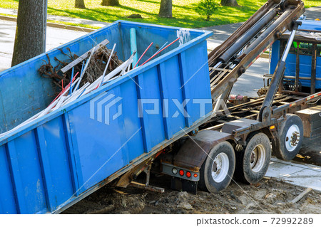 Construction trash loading the garbage dumpsters can waste construction trash dumpsters on house renovation. Construction trash loading the garbage dumpsters can waste construction trash dumpsters on house renovation. 72992289