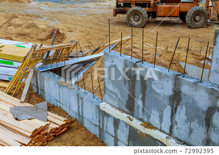 A woodentruss being lifted by a boom truck forklift in the building materials a stack of boards wood frame a new home A woodentruss being lifted by a boom truck forklift in the building materials a stack of boards wood frame a new home 72992395