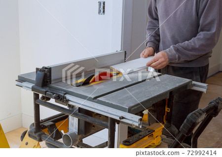 Woodworking detail on wood equipment carpentry circular saw cutting wooden plank blade with board close-up 72992414