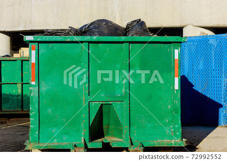 Truck loading a recycling container trash dumpsters being full with garbage container trash 72992552