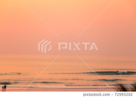 Sunset waves break in the Pacific Ocean on a California beach 72993282