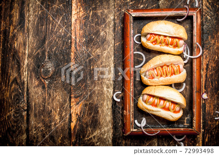 Hot dogs with mustard and tomato sauce on the Board. 72993498