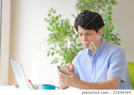 A businessman with a look that gave up holding a smartphone 72994364