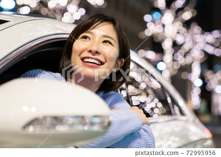 Young woman looking up at illumination 72995956