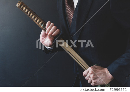 一個穿著西裝拿著日本劍的人 一個穿著西裝拿著日本劍的人 72996251