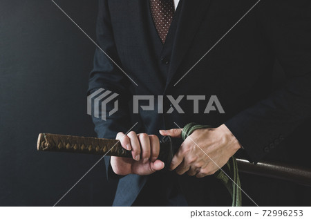 一個穿著西裝拿著日本劍的人 72996253