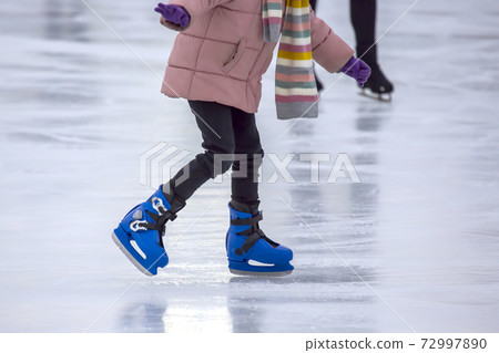 girl ice skating on an ice rink. Hobbies and sports. Vacations and winter activities. 72997890