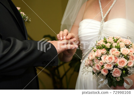 bride and groom wear wedding rings to each other bride and groom wear wedding rings to each other 72998108