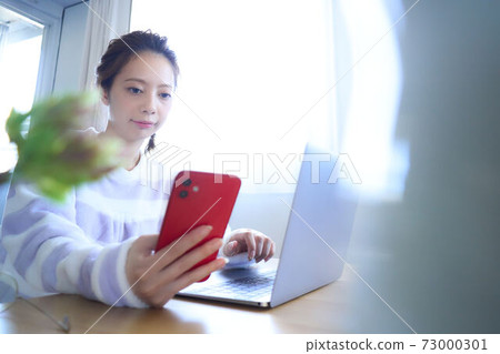 Young woman operating a personal computer in the room 73000301