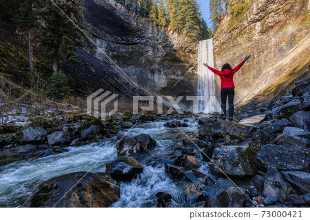 Girl watching a beautiful waterfall in Canadian Nature Girl watching a beautiful waterfall in Canadian Nature 73000421