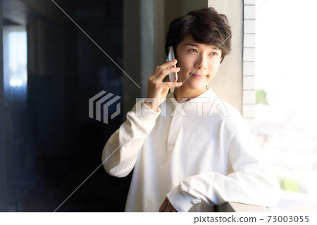 A young man calling with a smartphone 73003055